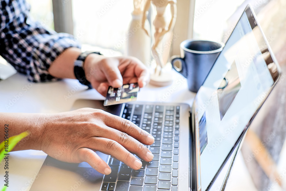 Online payment concept : Man's hand holding credit card while using computer laptop for online shopping or paying a bills. Online payment concept : Man's hand holding credit card while using computer laptop for online shopping or paying a bills.