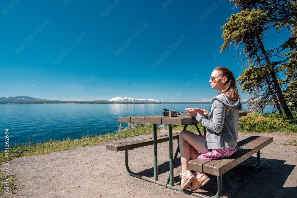 Woman tourist having a breakfast by Yellowstone Lake