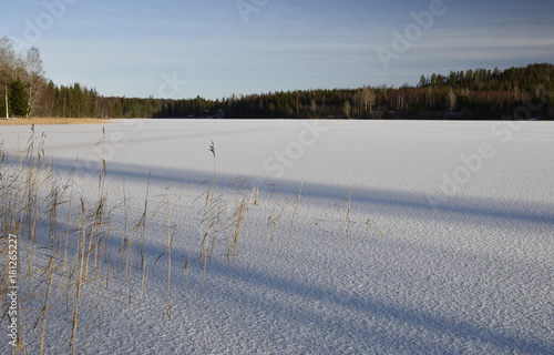 Thin ice on a lake with glittering snow