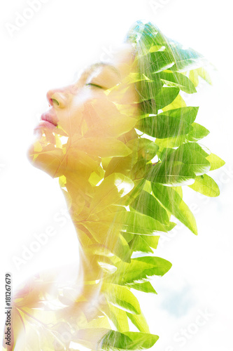 Fototapeta Podwójne naświetlenie młodej naturalnej urody relaksującej i delikatnie odchylającej głowę do tyłu, ponieważ jej czoło i włosy idealnie łączą się z jasnymi tropikalnymi liśćmi