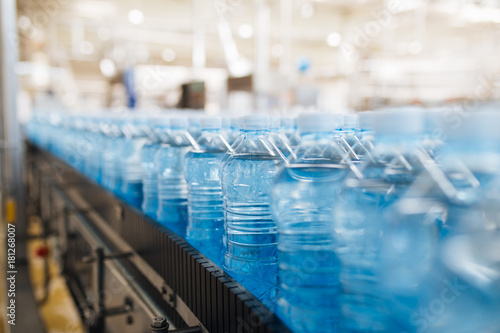 Bottling plant - Water bottling line for processing and bottling pure spring water into blue bottles. Selective focus. 