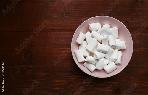 marshmallow in a pink plate on a wooden table