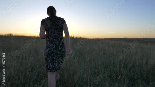 pregnant woman in field at sunset