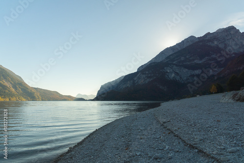 Sun sets behind the mountain on a calm evening on the Lago di Molveno  Trentino  Italy