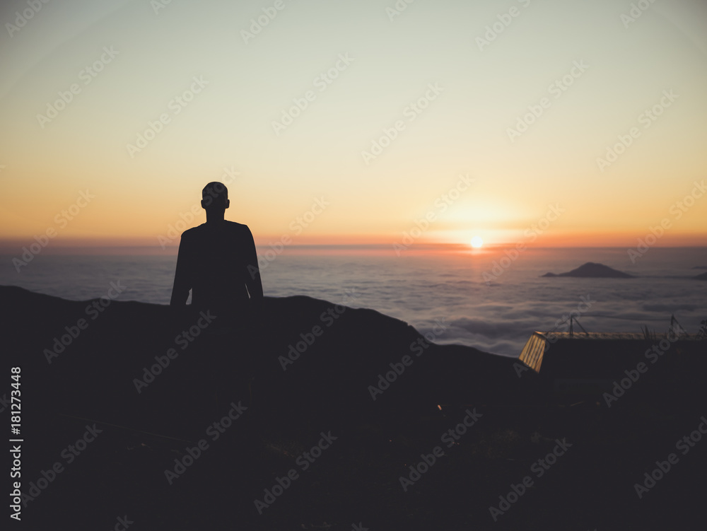 man standing sunset clouds mountains sky skyline