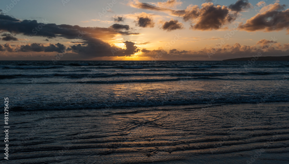 Beach sunset and gentile ocean waves in golden light