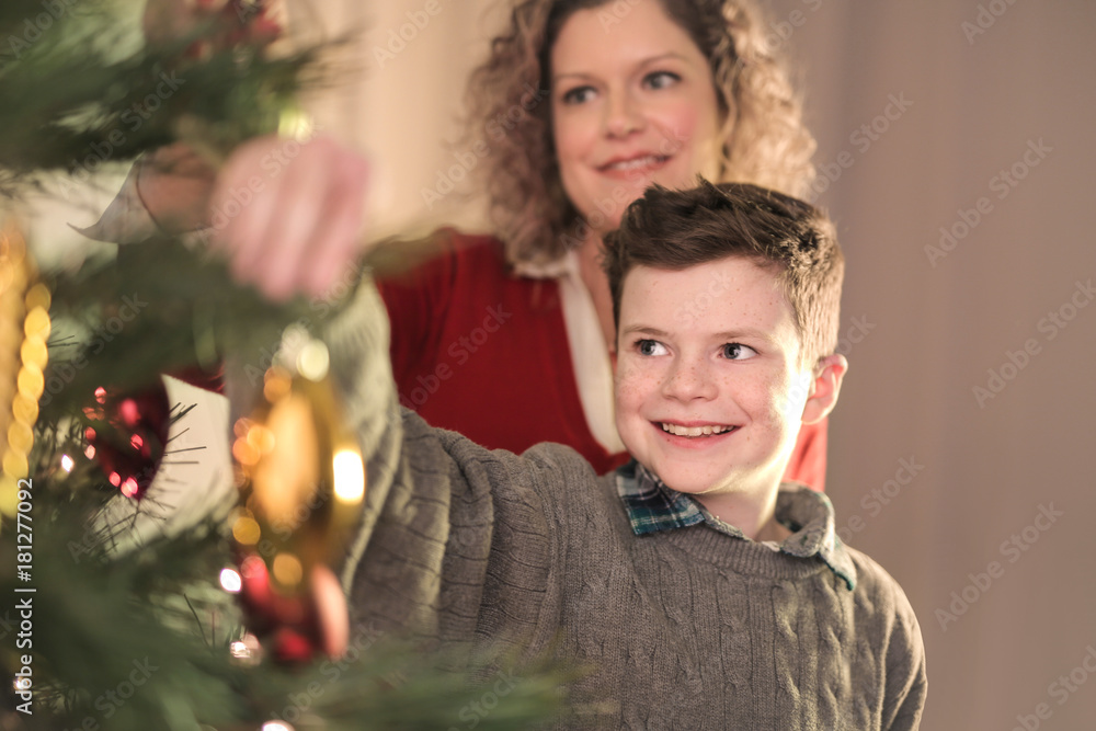 Son and mother making the christmas tree Son and mother making the christmas tree