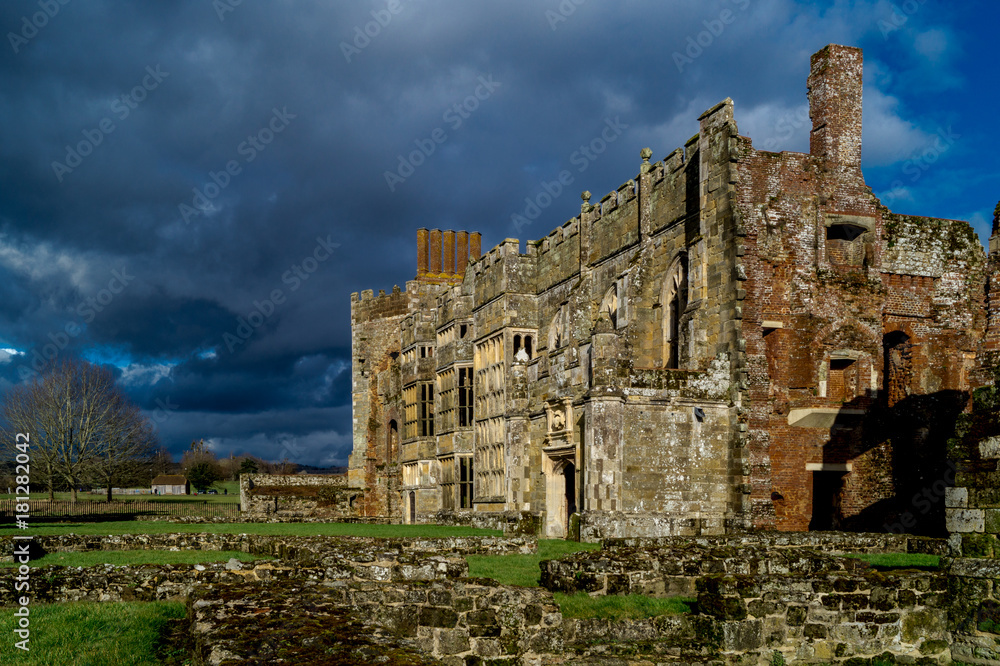Ruins of a castle in England with dark clouds in the background.