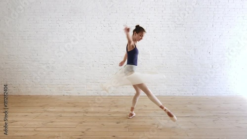 allerina perform pirouette on the white brick wall background
