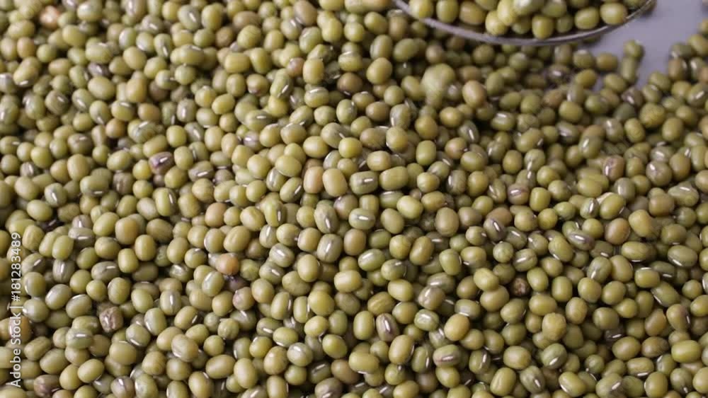 Slowly stirring then selecting a spoonful of organic mung beans. Slowly stirring then selecting a spoonful of organic mung beans.