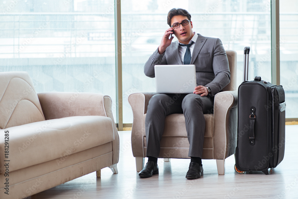 Fototapeta premium Young businessman in airport business lounge waiting for flight
