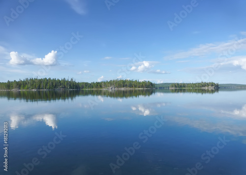 Summer water landscape. Blue sky and clear water of Lake Pyaozero with reflected clouds. Active tourism in nature reserve