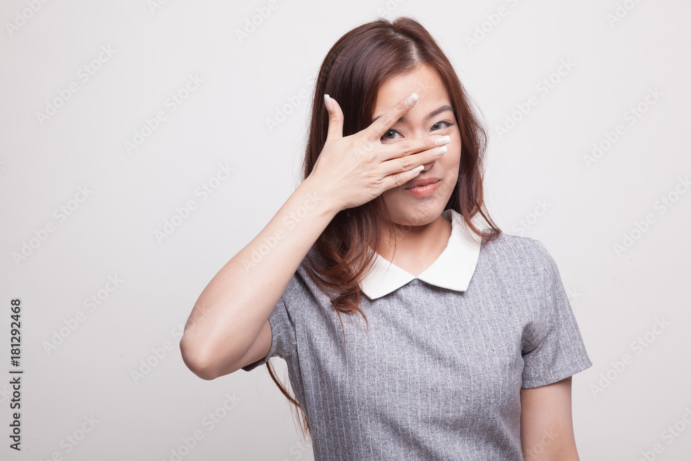 Beautiful young Asian woman peeking through fingers. Beautiful young Asian woman peeking through fingers.