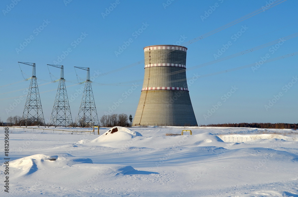 Obraz premium cooling tower on a background of blue clear sky and white snow, landscape