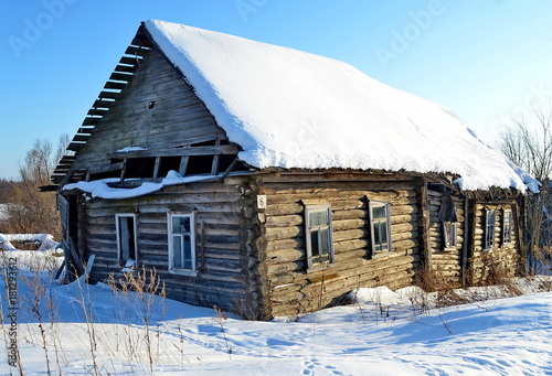 old abandoned house made of logs in snow © Kirill