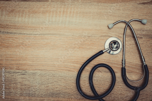 Stethoscope with blue tube on wood table top view with copy space. health and medical concept. vintage tone.
