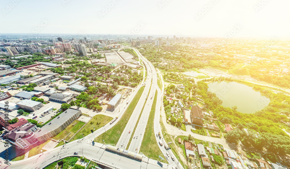 Aerial city view with crossroads and roads, houses, buildings, parks and parking lots, bridges. Helicopter drone shot. Wide Panoramic image.