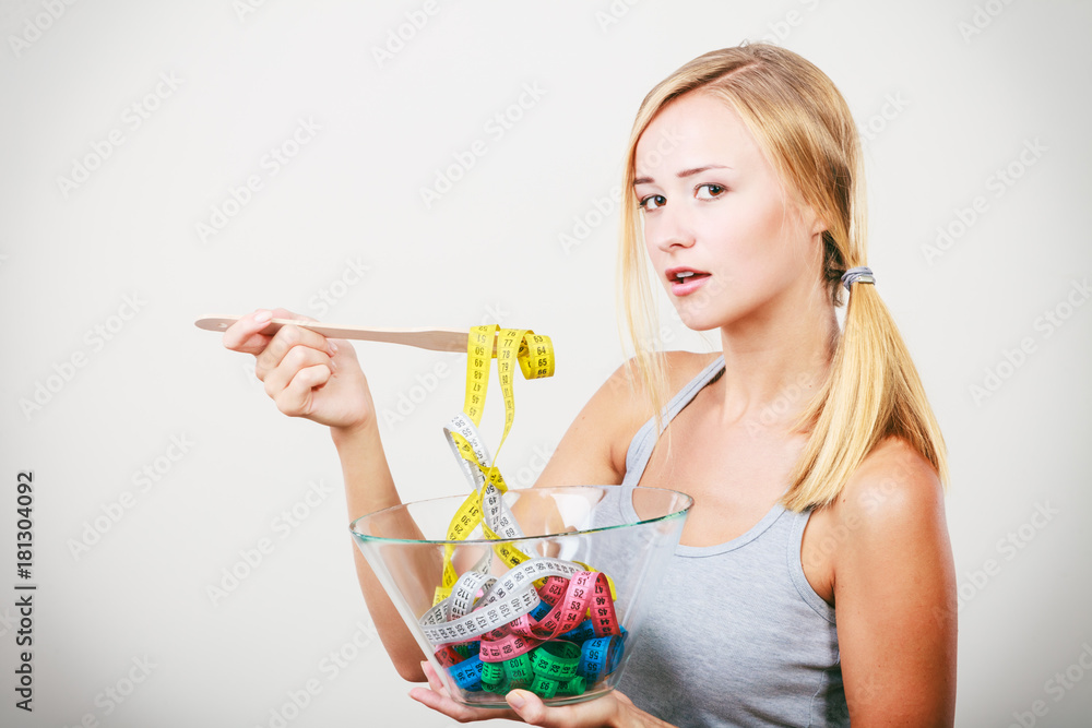 Diet. Girl with colorful measuring tapes in bowl Diet. Girl with colorful measuring tapes in bowl