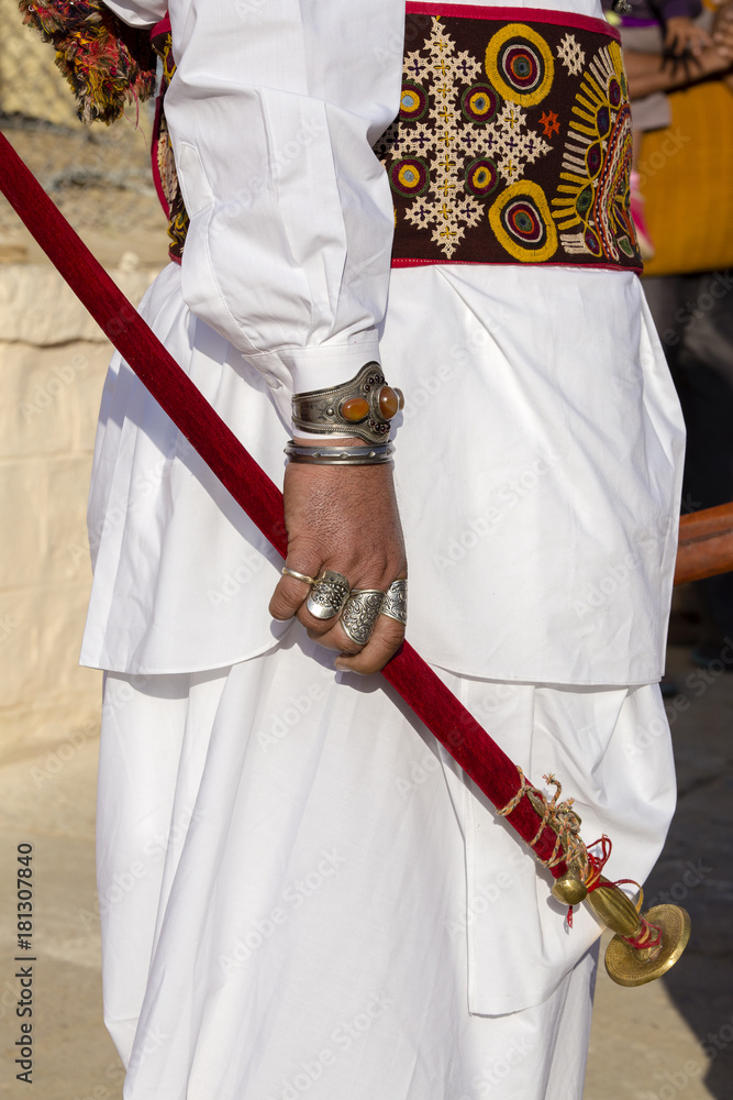 Beautiful man hands decorated with rings holds a saber at Desert Festival in Jaisalmer, Rajasthan, India.