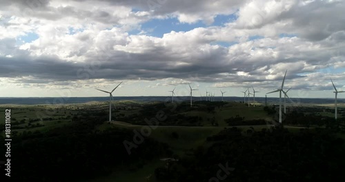 NSW windturbine electric power generating farm on hill top rotating propellers under cloudy sky in windy weather.
 photo