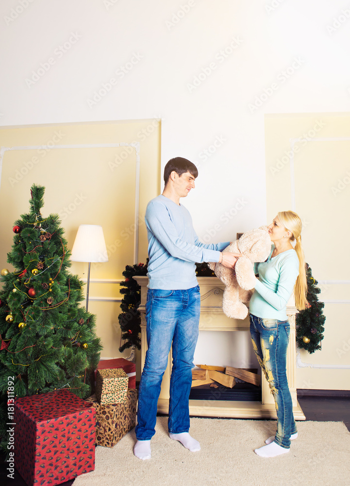 Fototapeta premium Young couple giving gifts for Christmas