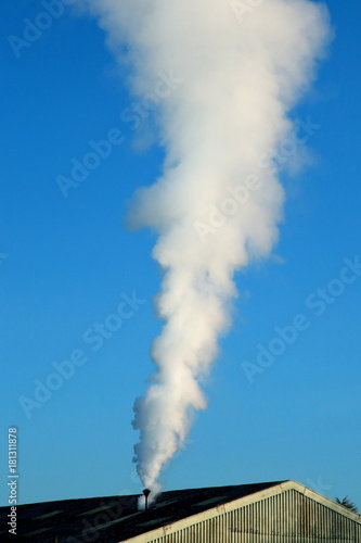 Smoke from factory against blue sky