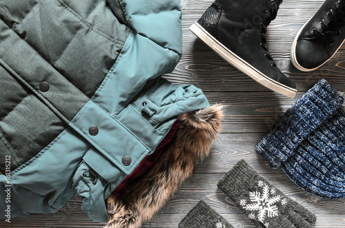 Women's warm winter clothing and accessories - jacket, black leather high top sneakers, gloves and hat. Wish list or shopping overview concept.  Fashion concept. View from above. Flat lay