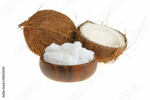 natural unrefined coconut oil. coconut in a cut and white natural coconut oil in a brown wooden round cup isolated on a white background