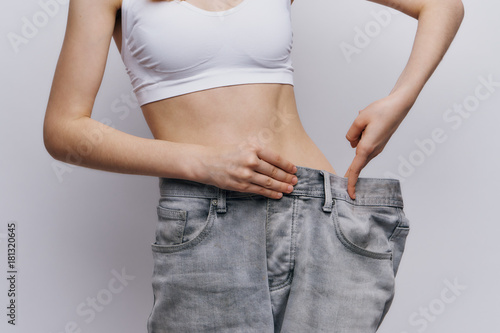 Young beautiful woman on a light background, diet, weight loss, progress, success