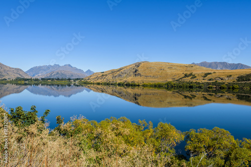 Reflections on Lake Hayes on a sunny day with clear sky  Queenstown  New Zealand.