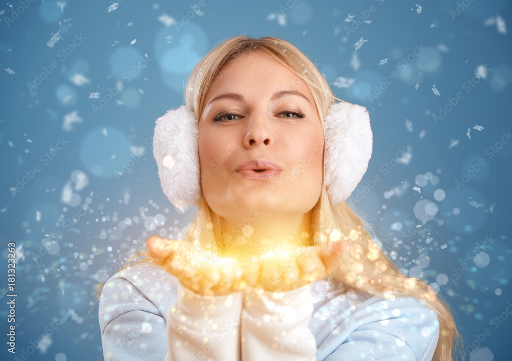 Christmas. A girl in winter clothes blowing on the snow. Christmas. A girl in winter clothes blowing on the snow.