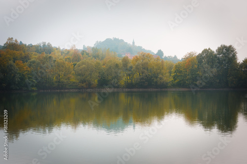 Fototapeta Naklejka Na Ścianę i Meble -  Fall Trees and Lake Reflection on a Foggy Morning