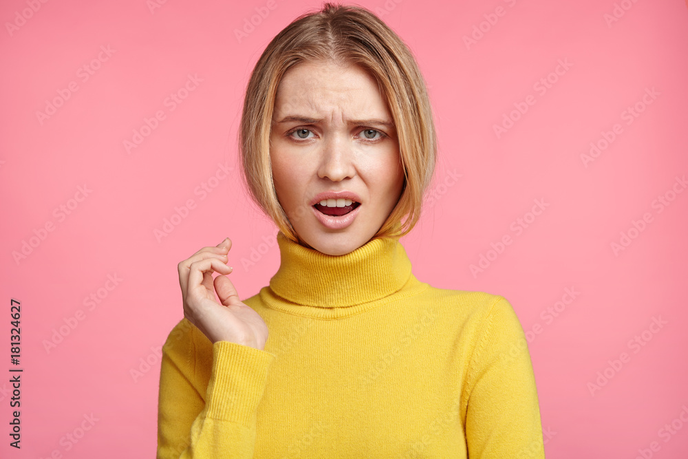 Upset discontent light haired female opens mouth in dissatisfaction, being displeased with bad news or comments, has unhappy expression, isolated over pink background. Disappointment and displeasure Upset discontent light haired female opens mouth in dissatisfaction, being displeased with bad news or comments, has unhappy expression, isolated over pink background. Disappointment and displeasure