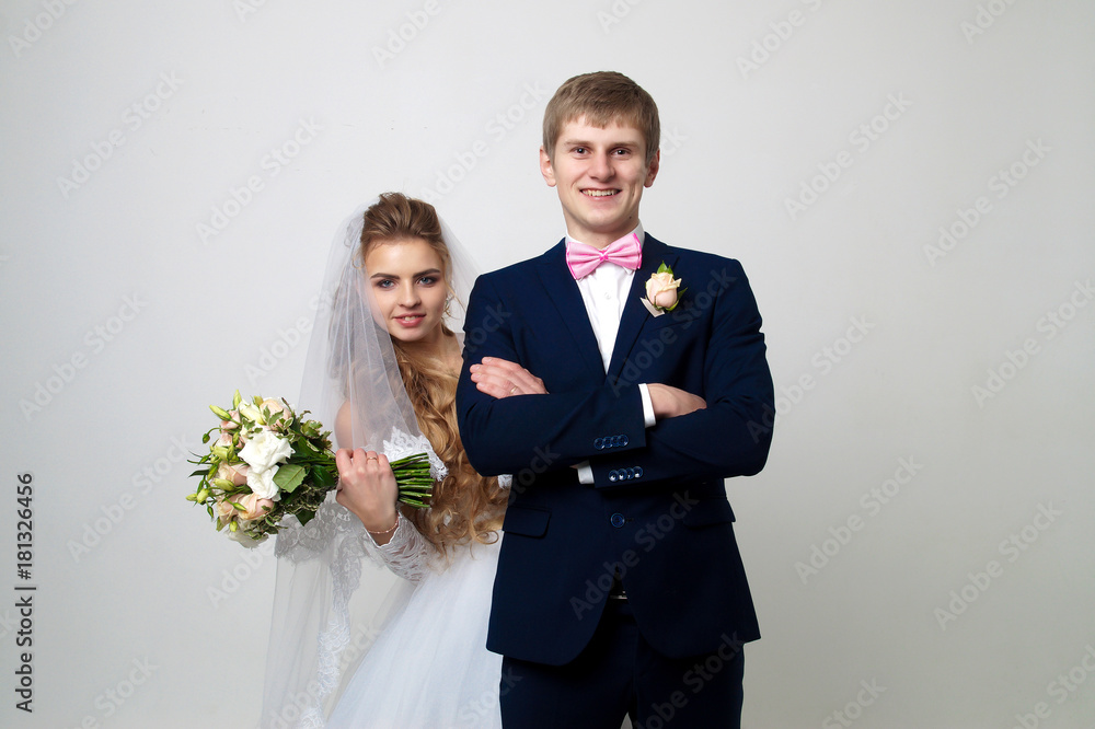 Beautiful young bride and groom posing at studio Beautiful young bride and groom posing at studio