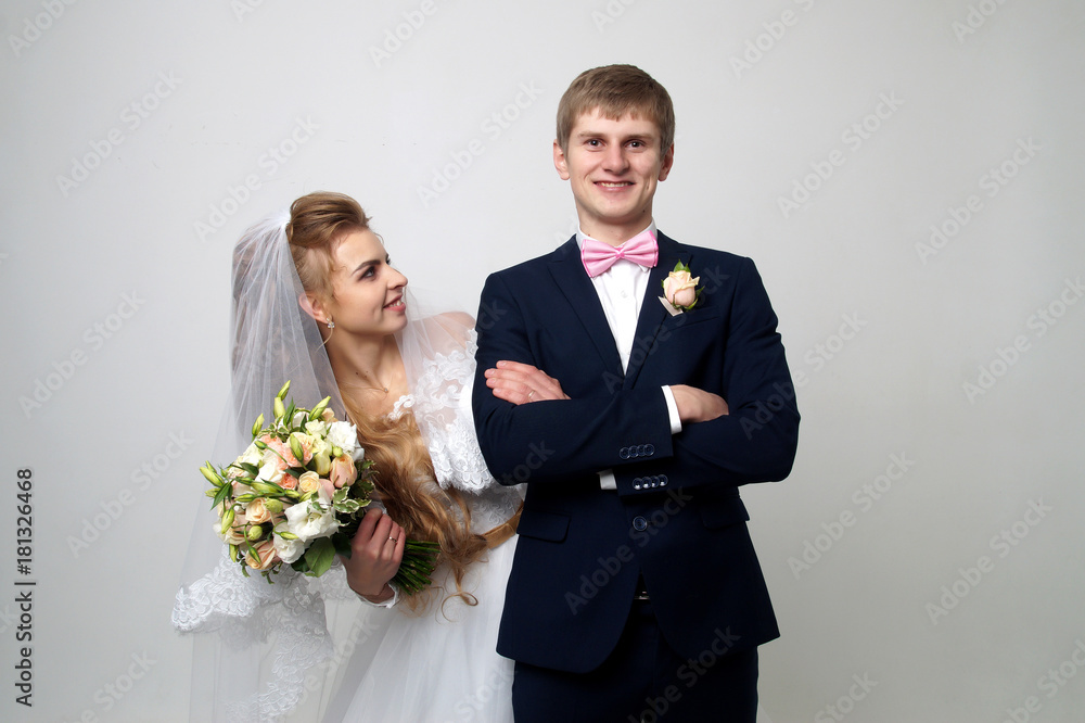 Beautiful young bride and groom posing at studio Beautiful young bride and groom posing at studio