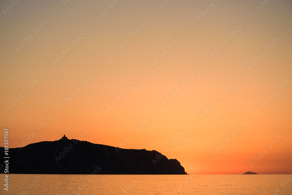 People enjoy Sunset on Bazia beach, Falcone, Sicily. In the background the sanctuary of Tindari