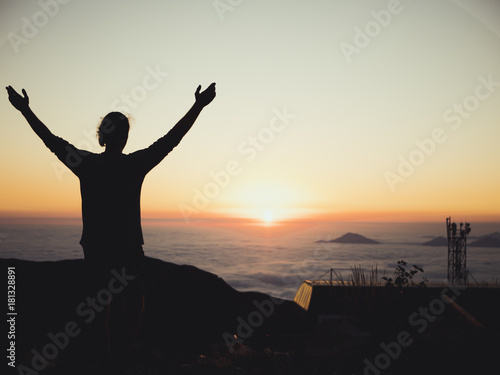 man standing sunset orange clouds mountains sky skyline