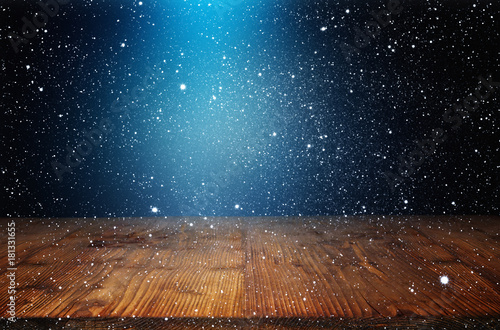Night sky with snowfall and wooden stage