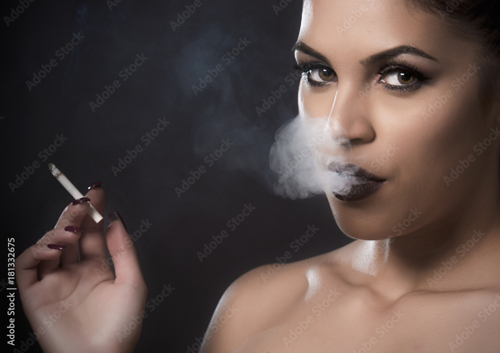 Obraz premium Beautiful woman with smoke from a cigar