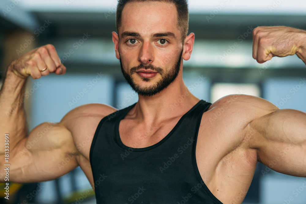 Young athlete posing with a torso for photography on a brick wall background. Bodybuilder, athlete with pumped muscles, breast and arm rescue Young athlete posing with a torso for photography on a brick wall background. Bodybuilder, athlete with pumped muscles, breast and arm rescue