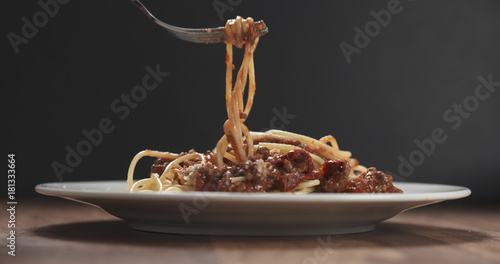 eating spaghetti with bolognese sauce with fork