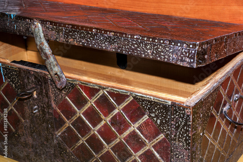 Fotografija Semi-open big old wooden coffer, upholstered in wrought iron with geometric pattern squares