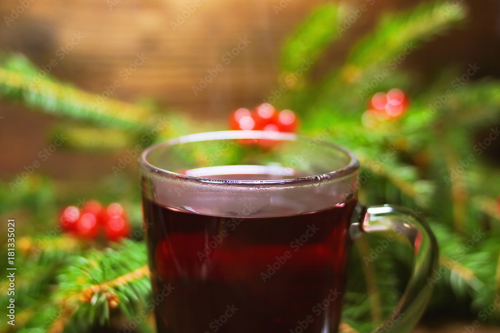 ashberry tea in a glass cup. fir branches with rowan on a wooden board. Christmas theme. ashberry tea in a glass cup. fir branches with rowan on a wooden board. Christmas theme.