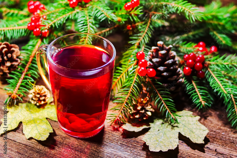 ashberry tea in a glass cup. fir branches with rowan on a wooden board. Christmas theme. ashberry tea in a glass cup. fir branches with rowan on a wooden board. Christmas theme.