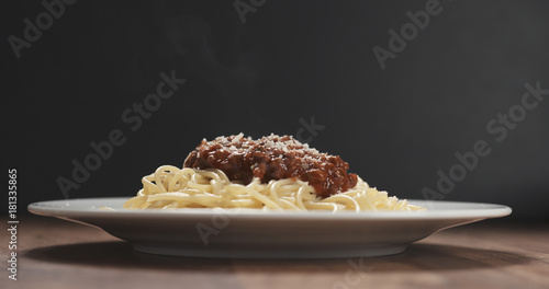 classic spaghetti bolognese with parmesan on plate on table