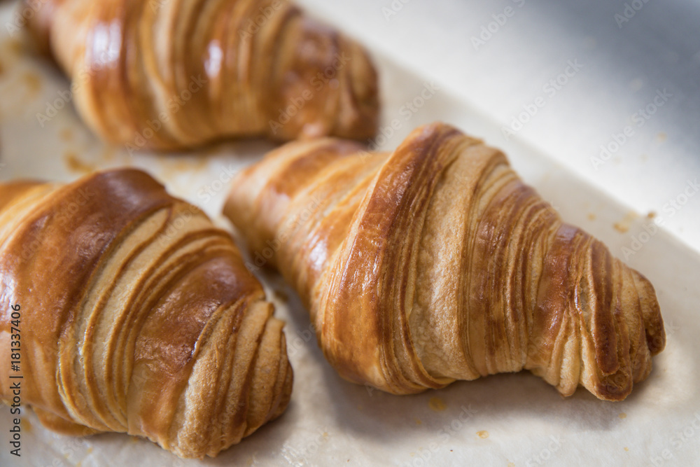 Freshly baked croissants lies with baking paper
