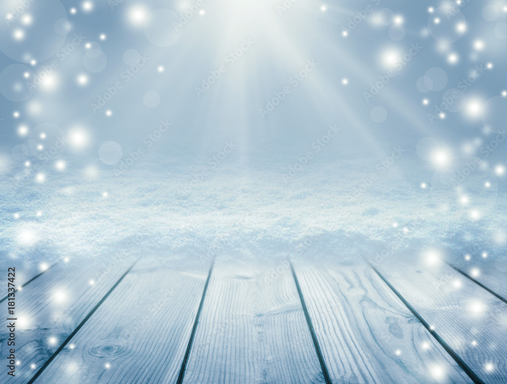 Blue wooden background and winter. Empty table and blizzard. Christmas background. Sun rays and snow. New Year background.
