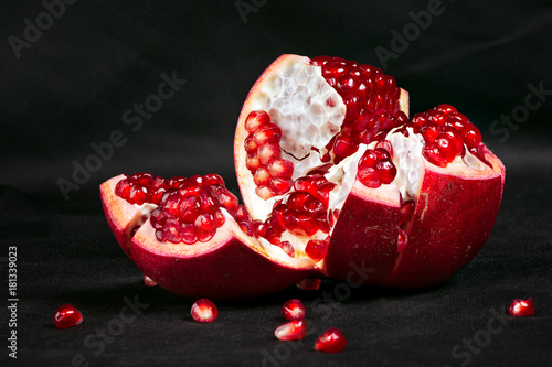 Fotografija cut garnet on a dark background, still life with a pomegranate