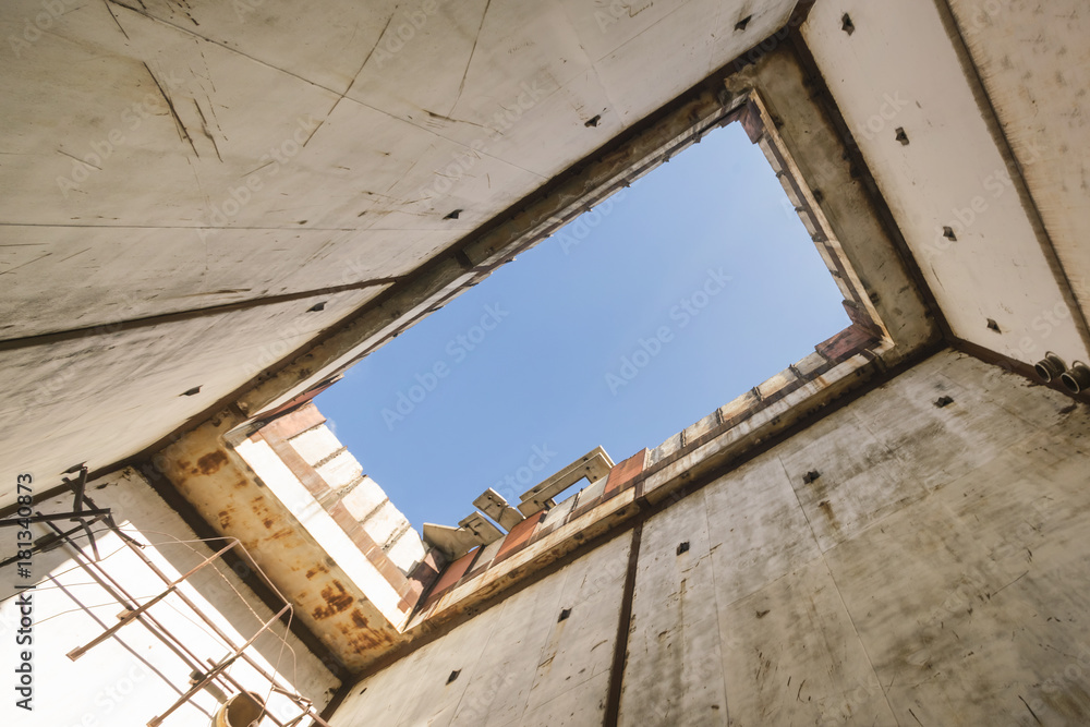 Blue sky through a hole in the roof of the old concrete building Blue sky through a hole in the roof of the old concrete building