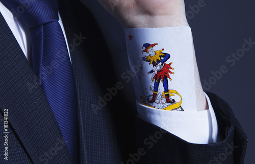 Slika na platnu A partial view of a businessman with a Joker card in a sleeve as symbol of cheat